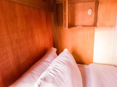 a bed in a room with a wooden wall at Loki Cusco in Cusco