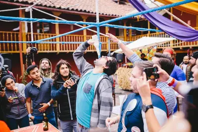 a crowd of people standing around with their hands in the air at Loki Cusco in Cusco