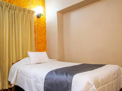 a bedroom with a bed and a yellow curtain at LO NUESTRO House in Cusco