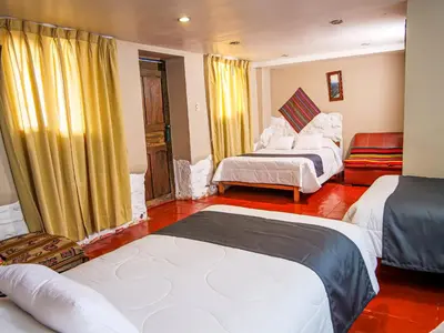 a hotel room with two beds and yellow curtains at LO NUESTRO House in Cusco