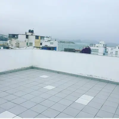 a white balcony with a view of a city at El Refugio in Punta Hermosa