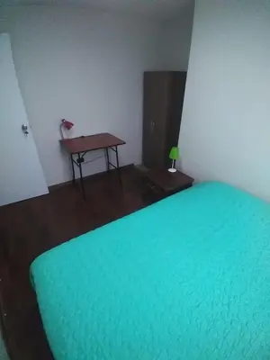 a room with a green bed and a table at Arena Costa Lima private rooms Peru in Lima
