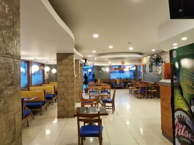 a dining room with tables and chairs in a restaurant at Hotel Dia y Noche in Lima