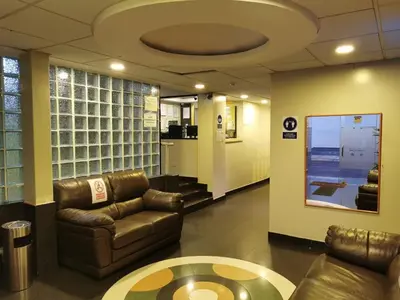 a lobby with a couch and a table in a room at Hotel Dia y Noche in Lima