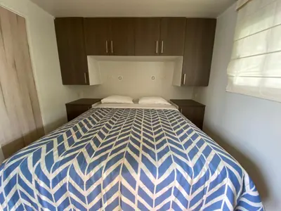 a blue and white bed in a small room at Casa Caravanas in Paracas
