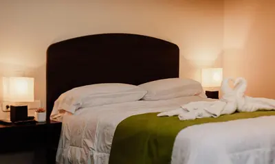 a bedroom with a bed with two towels on it at Real Hotel in Huánuco