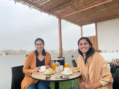 two women sitting at a table with food at Mandala in Pisco