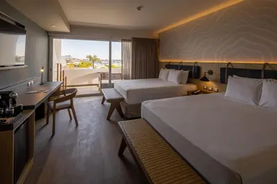 a hotel room with two beds and a desk at Aranwa Paracas Resort & Spa in Paracas