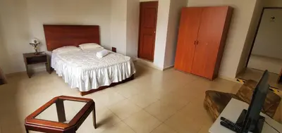 a bedroom with a bed and a chair in a room at Waldorf in Lima