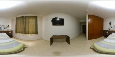 a room with two beds and a tv on the wall at Waldorf in Lima