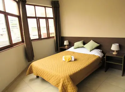 a bedroom with a bed with a yellow towel on it at Waldorf in Lima
