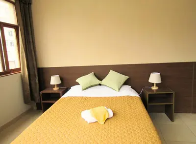 a bedroom with a bed with yellow sheets and pillows at Residencial Waldorf in Lima