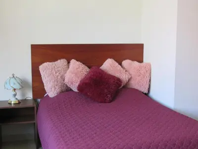 a bed with pink and purple pillows on it at Residencial Waldorf in Lima