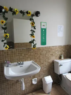 a bathroom with a sink and flowers on the wall at Residencial Waldorf in Lima