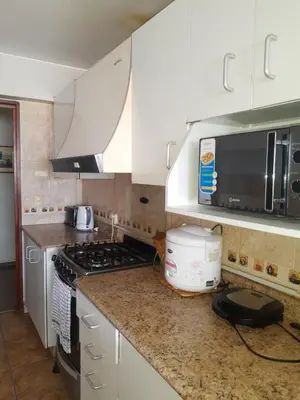 a kitchen with white cabinets and a stove top oven at suite pardo CAA Miraflores in Lima