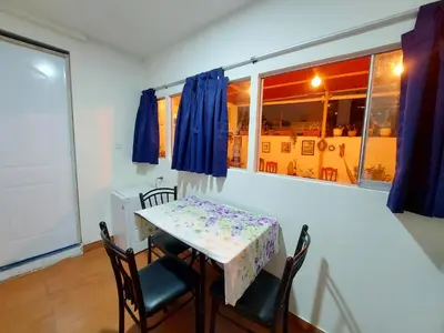 a dining room with a table and chairs and a window at Cozy and fully furnished apartment in Miraflores in Lima
