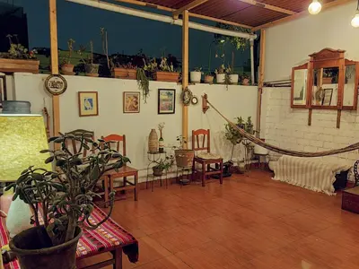 a living room with a table and chairs and a plant at Cozy and fully furnished apartment in Miraflores in Lima