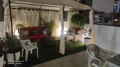 a living room with a couch and chairs on a balcony at Habitación RRB in Lima