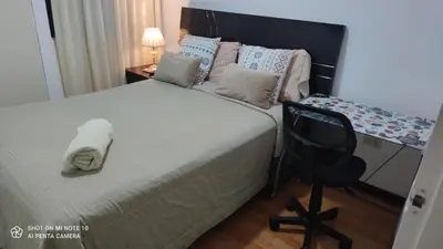 a bedroom with a bed and a desk and a chair at Habitación RRB in Lima