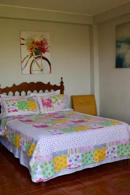 a bedroom with a large bed with a colorful comforter at Los Naturales in Huaral