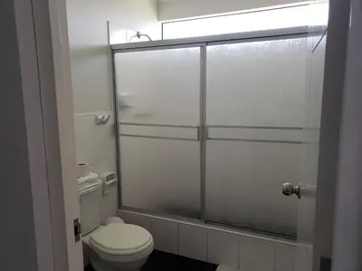 a bathroom with a toilet and a glass shower door at Los Naturales in Huaral
