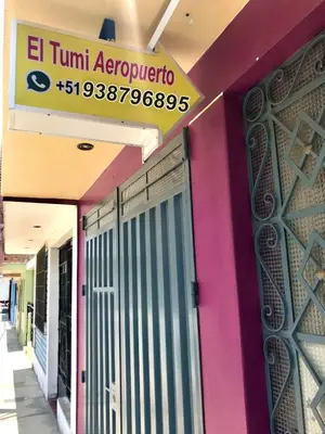 a sign on the side of a building with a door at EL TUMI - Aeropuerto in Lima