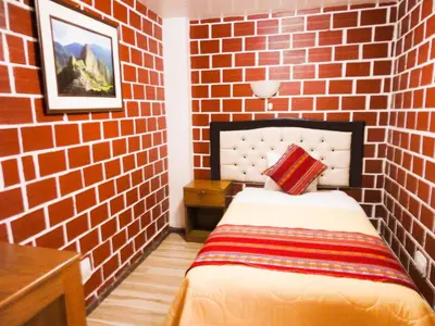 a red brick walled room with a bed in it at Hostal Encanto Machupicchu in Machu Picchu