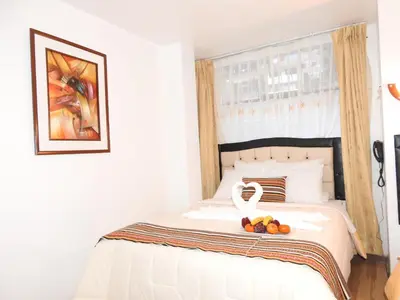 a bedroom with a white bed with fruit on it at Hostal Encanto Machupicchu in Machu Picchu