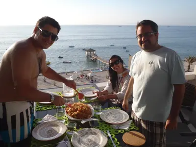 a group of people standing around a table with food at Paracas top tower beach front in Paracas