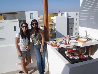 two women standing in front of a kitchen with food at Paracas top tower beach front in Paracas
