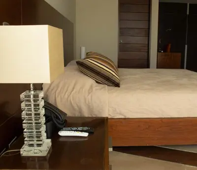 a bedroom with a bed and a lamp on a table at Hotel & Hacienda La Caravedo in Ica