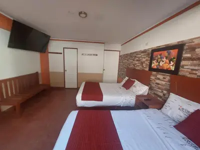 a hotel room with two beds and a television at Hotel Manantial in Churín