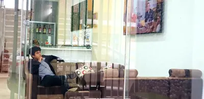a man sitting on a couch in a room at Hospedaje Pueblo Viejo in Casa Blanca