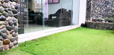 a room with green grass on the side of a building at Hospedaje Pueblo Viejo in Casa Blanca