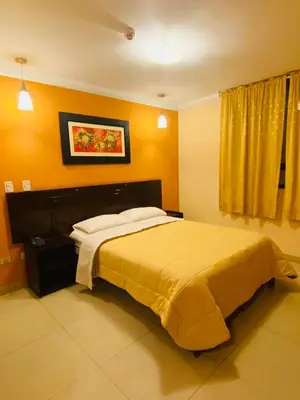a bedroom with a large bed with yellow walls at Royal Garden Hotel in Lima