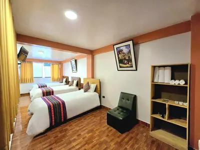 a hotel room with two beds and a chair at Amakonkay Machupicchu in Machu Picchu