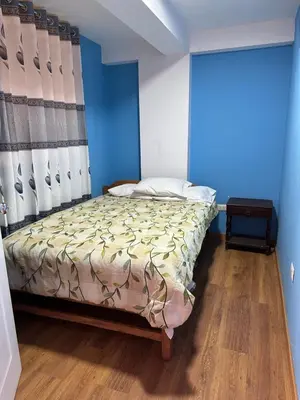 a bedroom with a bed with a blue wall at Departamento Don Santiago Centro in Cusco