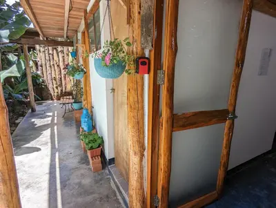 a hallway with potted plants on the side of a house at FRANKFURTER HOF FAMILIAR Oxapampa in Oxapampa