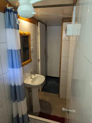 a bathroom with a sink and a shower at FRANKFURTER HOF FAMILIAR Oxapampa in Oxapampa