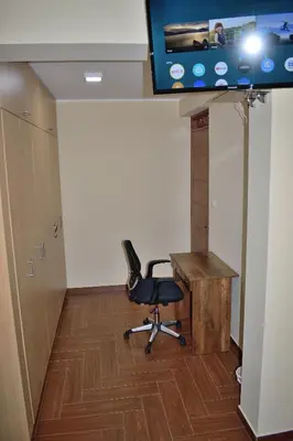 an office with a chair and a desk and a tv at Apartamentos Las Americas in Lima