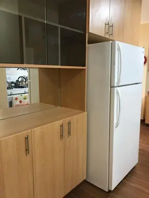a kitchen with a white refrigerator and wooden cabinets at Apartamentos Las Americas in Lima