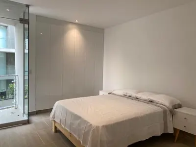 a white bedroom with a bed and a window at Vive - Descansa - Disfruta in San Bartolo