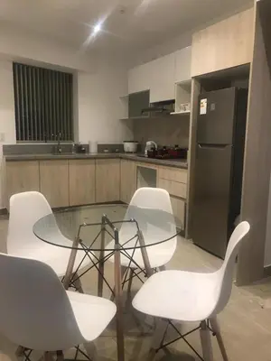a kitchen with a glass table and white chairs at Vive - Descansa - Disfruta in San Bartolo