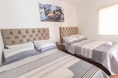 a bedroom with two beds and a window at Nakua Paracas Lodge in Paracas