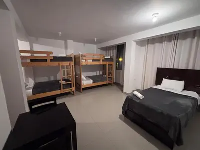 a room with two bunk beds and a television at Hotel Munay in Paracas