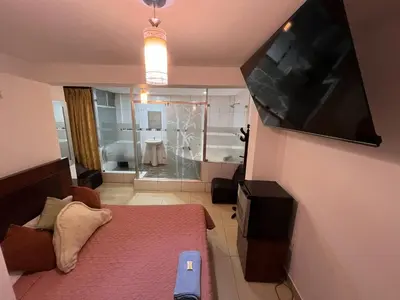 a small room with a bed and a large television at Hostal Milagros in Chancay