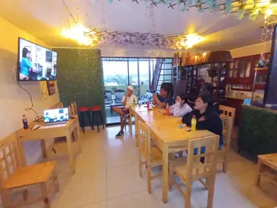 a group of people sitting at a table in a restaurant at Hostal Milagros in Chancay
