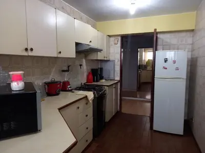 a kitchen with white cabinets and a white refrigerator at apartamento CAA pardo in Lima