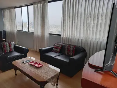 a living room with two chairs and a coffee table at apartamento CAA pardo in Lima