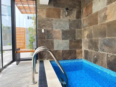 a bathroom with a large tub with a tile wall at Osma by Wynwood House in Lima